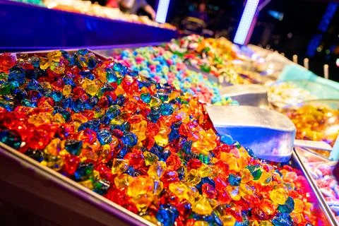 Colorful assorted candies in bulk bin under bright lights Stock Photos