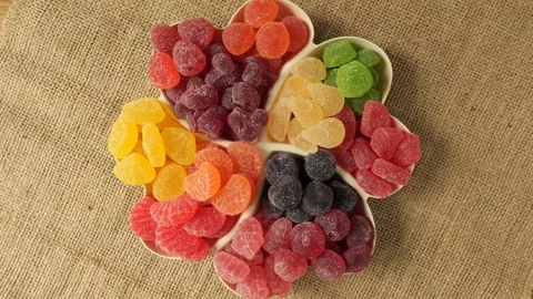 Colorful assorted gummy candies rotating in a flower dish. Stock-Footage 335436601