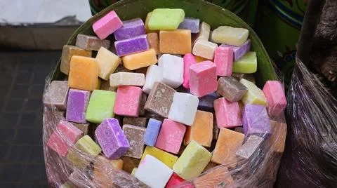 A colorful assortment of square-shaped traditional soaps stacked inside a c.. Stock-Fotos