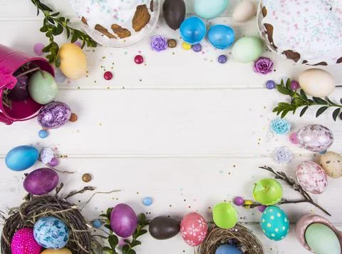 Colorful background with Easter eggs on white wooden board background. Happy  Stock Photos