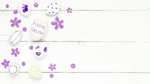 Colorful background with Easter eggs on white wooden board background. Stock Photos