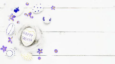 Colorful background with Easter eggs on white wooden board background. Stock Photos
