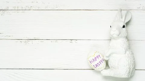 Colorful background with Easter eggs on white wooden board background. Stock Photos