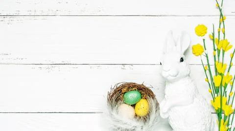 Colorful background with Easter eggs on white wooden board background. Stock Photos