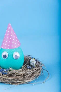 Colorful background with Easter funny cute egg on blue background. Happy East Stock Photos