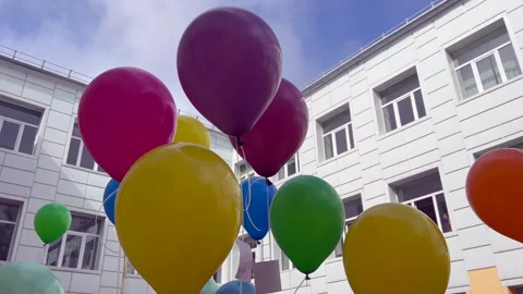 Colorful balloons floating in front of school building Stock Footage 302195452