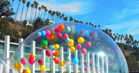 Colorful balloons inside a transparent bubble dome outdoors Stock Footage 292708858