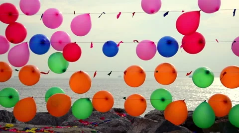Colorful balloons for target practice floating on a string near sea Stock Footage 48990023