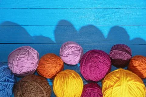 Colorful balls of wool on  blue rustic table. Copy space Stock Photos