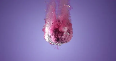 Colorful bath bomb falling down into clean water against blue background. Filmed Stock Footage 152820617
