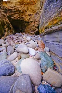 Colorful Beach Pebbles at the Cave Entrance Stock Photos