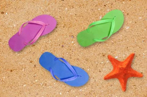 Colorful beach shoes and starfish over yellow sand background Foto stock