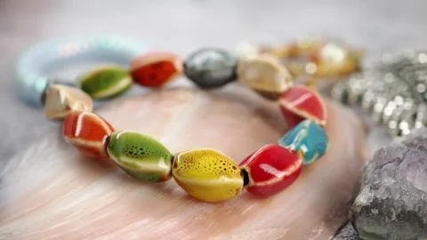 Colorful beads on a table with shells and stones Stock Footage 336984362