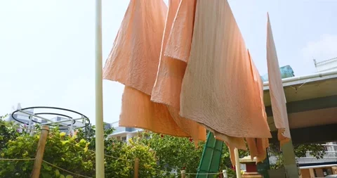 Colorful bed linen is drying outside on a sunny day. Vidéo 236940556