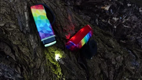 A colorful bicycle light is lying on the trunk and blinking. The film was mad Video stock 151960847