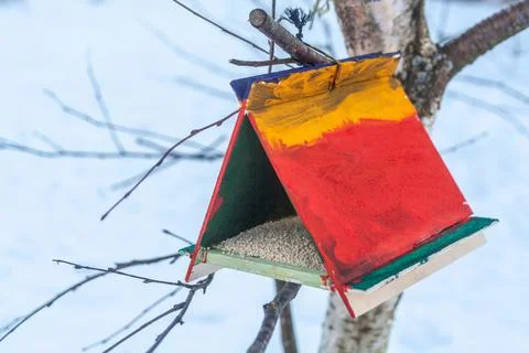 Colorful bird feeder with seeds, made and painted by children. Caring for nature Stock Photos