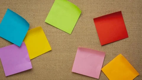 Colorful blank sticky notes being dropped onto canvas board Stock Footage