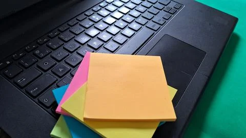 Colorful blank sticky notes placed on a black laptop keyboard surface Stock Photos