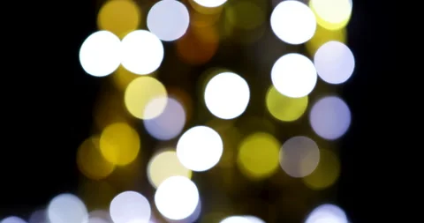 Colorful bokeh lights, yellow, orange, white and purple, black background Stock Footage