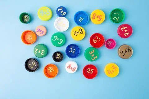 Colorful bottle caps with multiplication problems on blue background, flat .. 写真素材