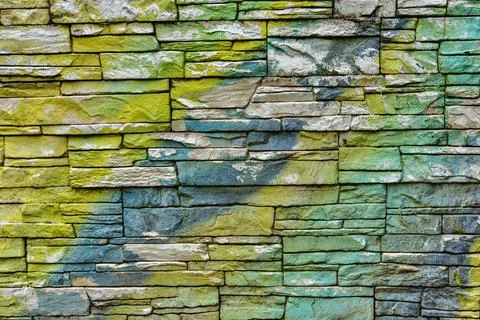 Colorful brick wall pattern in yellow, green and blue stones Stock Photos