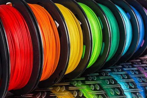 Colorful bright  row of spool 3d printer filament black metal background Stock Photos