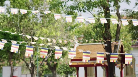Colorful Buddhist Prayer Flags before a Temple, Green Trees, Static Shot Stock Footage 341576408