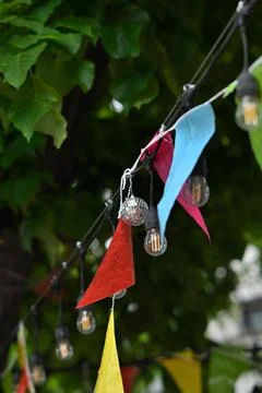 Colorful bunting and string lights in garden Stock Photos