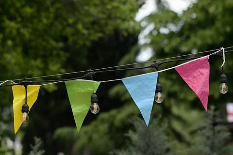 Colorful bunting and string lights in garden Stock Photos