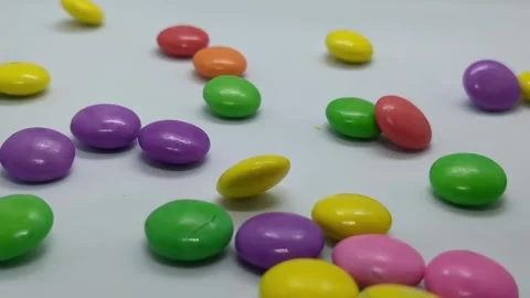 Colorful Candy-Coated Chocolates Scattered on White Background Stock Footage 302705623