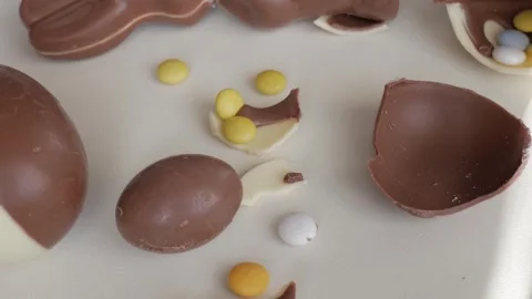 Colorful Candy Inside Broken Easter Chocolate Eggs on a Festive Table Stock Footage 333111252