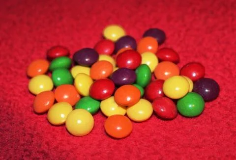 Colorful candy on red background Stock Photos