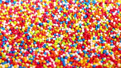 Colorful candy sprinkles bouncing and moving randomly in a dynamic motion, .. Stock Footage 333775357