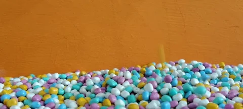 Colorful Candy Sprinkles Falling Down on Orange Background. Stock Footage 341906225