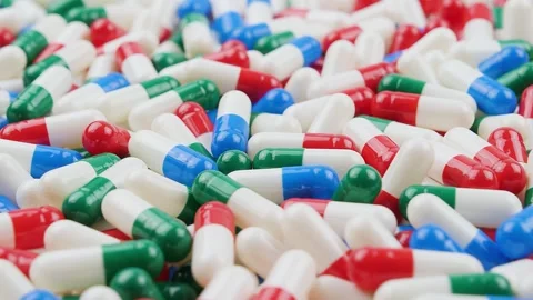 Colorful capsules scattered on a surface in a random pattern Stock Footage 327137934