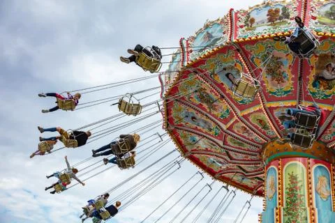 Colorful carousel on cloudy sky background. Oktoberfest, Bavaria, Germany Stock Photos