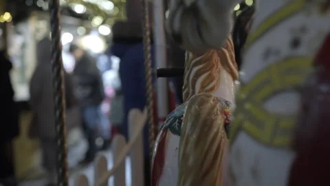 Colorful carousel horses in festive setting with blurred background figures 스톡 동영상 340264747