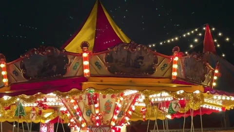 Colorful Carousel Spins Under Bright Lights at a Nighttime Fair Celebration Stock Footage 301136439