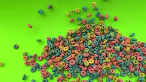 Colorful Cereal Rings Falling and Scattering Across Bright Green Background in Stock Footage 346796995