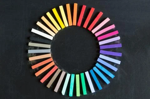 Colorful chalks lined up rounded on circle on blackboard background Stock Photos