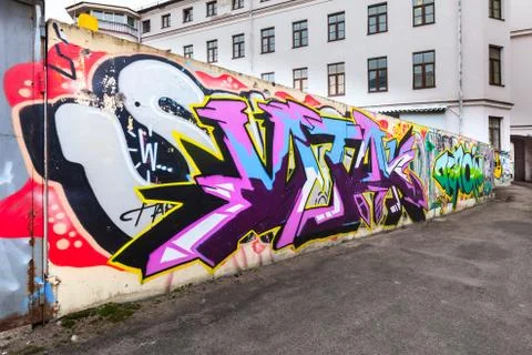 Colorful chaotic graffiti text patterns over fence Fotos de archivo