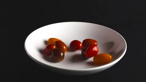 Colorful Cherry Tomatoes Falling into a White Bowl in Slow Motion Stock Footage 341397799