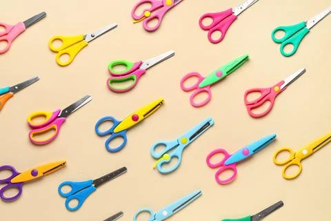 Colorful childrens scissors pattern on a beige background, school supplies an Stock Photos