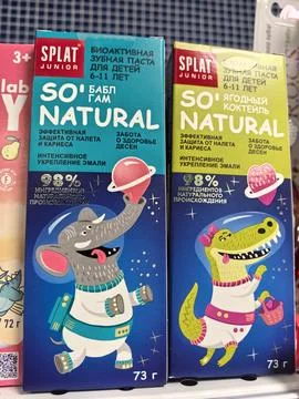 Colorful children's toothpaste packaging featuring friendly animal characters Stock Photos