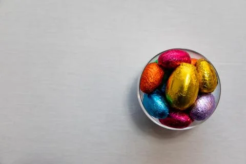 Colorful chocolate easter eggs in a transparent bowl isolated with whit backg Stock Photos