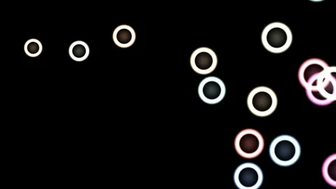 Colorful circles shine on a dark background with a soft Stock Footage 338300476