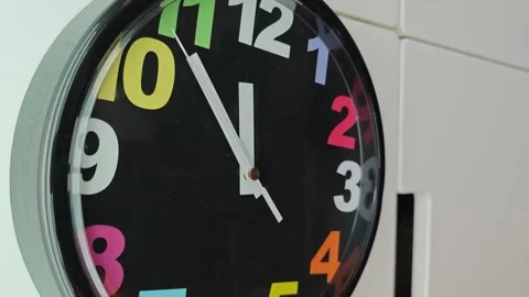 Colorful clock displays time and moves hands to show passing minutes Stock Footage 340462034