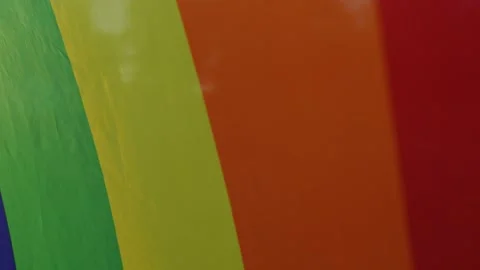 Colorful close-up view of rainbow flag in the wind backlighted 스톡 동영상 250472045