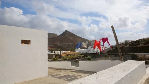 Colorful clothes drying in the wind by a white house in Haria village, Lanzarote Stock Footage 89146912