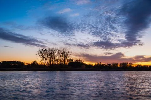 Colorful clouds after sunset over the lake Stock Photos